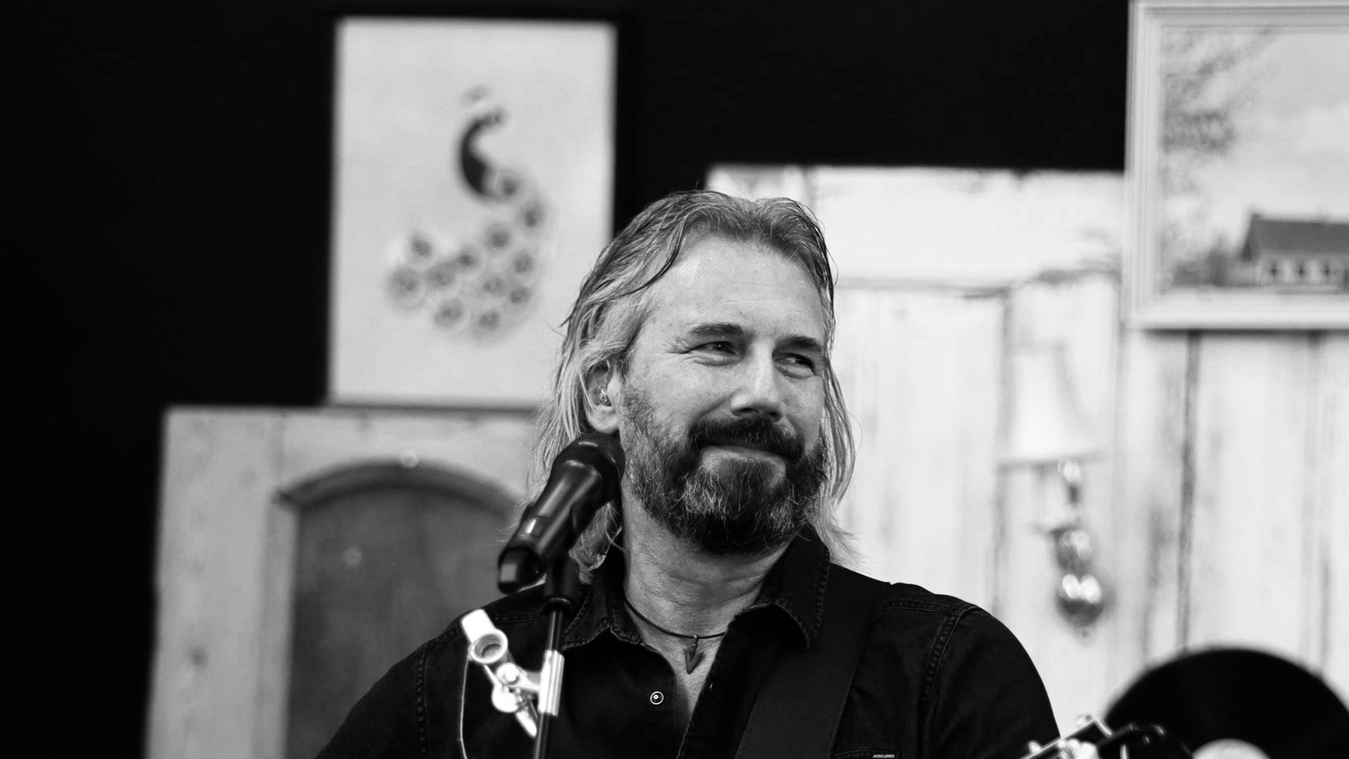 Musiker Allan Grønbæk spiller på sin guitar foran mikrofonstativ